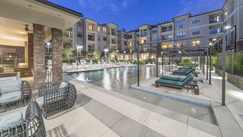 a swimming pool with lounge chairs in front of an apartment building at The Hendrix, Atlanta